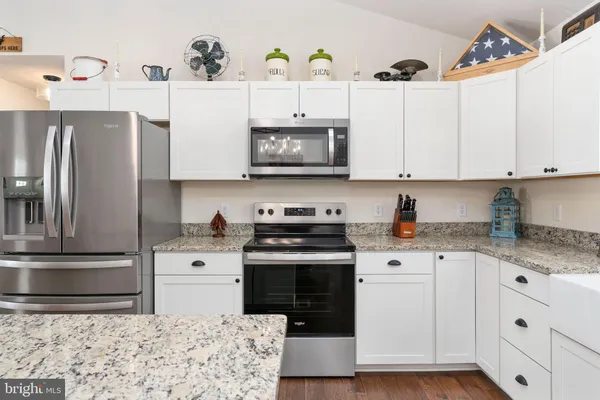a kitchen with stainless steel appliances granite countertop a stove a sink and a refrigerator