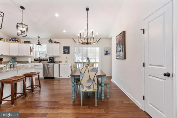 a view of a dining room with furniture a chandelier and wooden floor