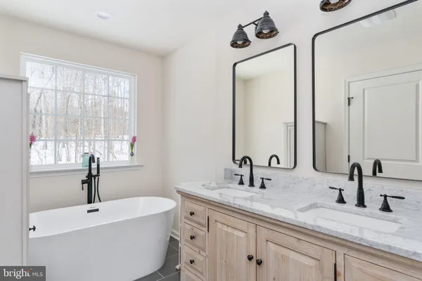 a bathroom with a double vanity sink window and a mirror