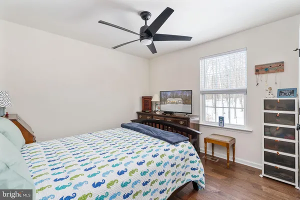 a bedroom with a bed a window and a flat screen tv