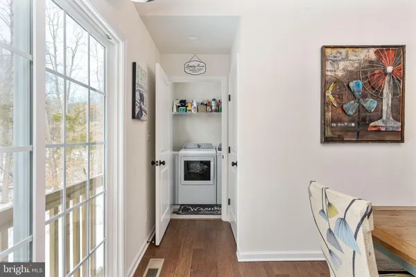 a view of a hallway with a view of bedroom with wooden floor