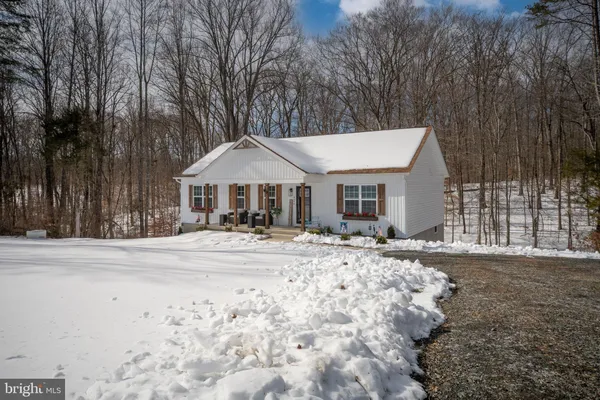 a front view of a house with a yard and shrubs