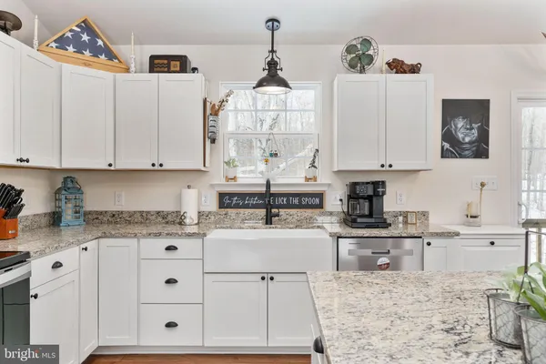 a kitchen with granite countertop white cabinets and white appliances