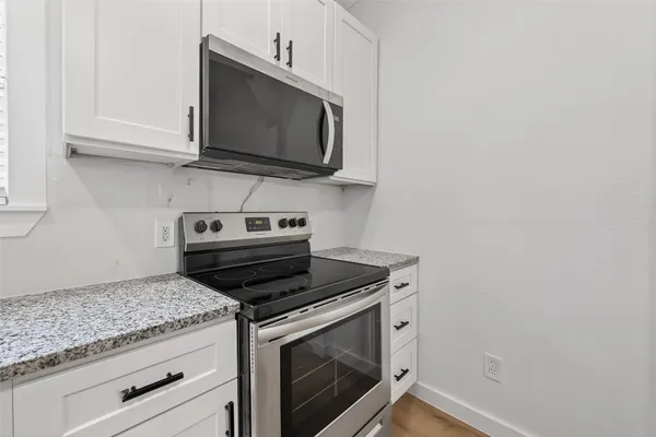 a kitchen with granite countertop a sink stove and refrigerator