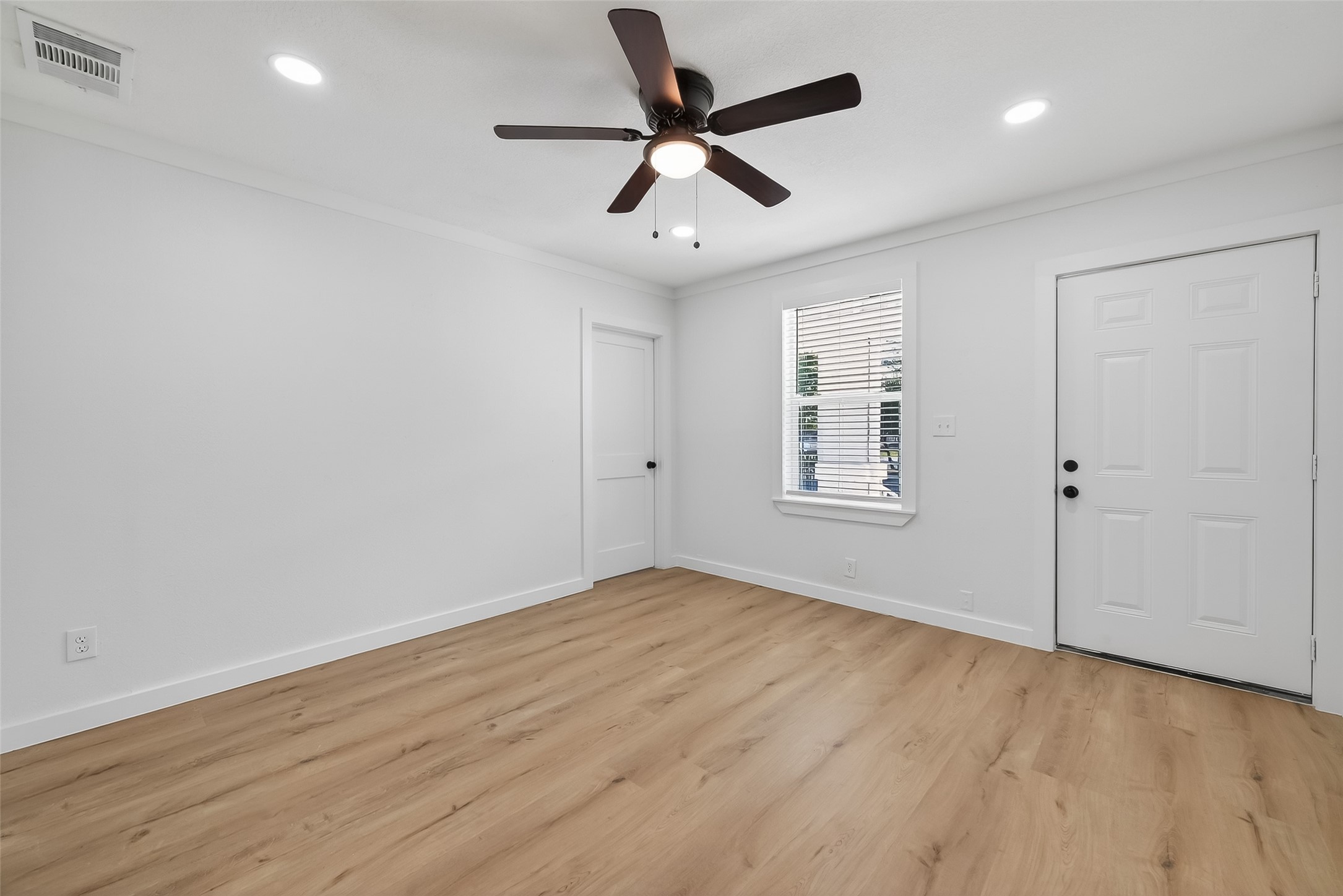 2202 Hutchins Street, Unit B Houston, TX 77003 - Photo 6 of 30 an empty room with wooden floor ceiling fan and windows