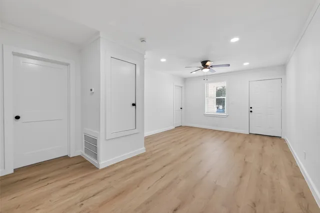 a view of empty room with wooden floor and ceiling fan