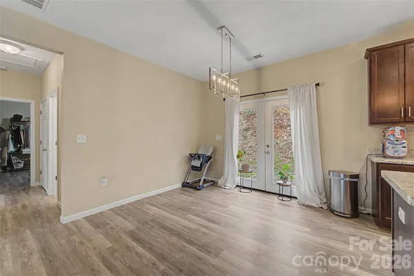 a view of empty room with fireplace and wooden floor