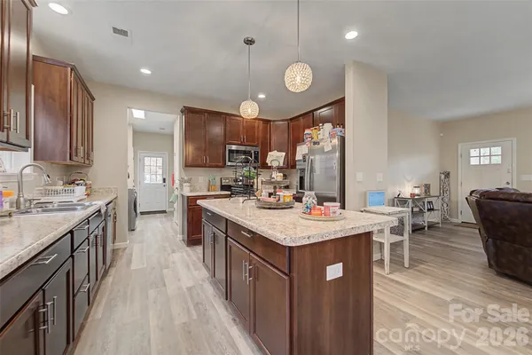 a kitchen with a sink stove cabinets and wooden floor