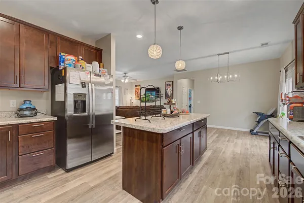 a kitchen with stainless steel appliances granite countertop a sink a stove and a wooden floors