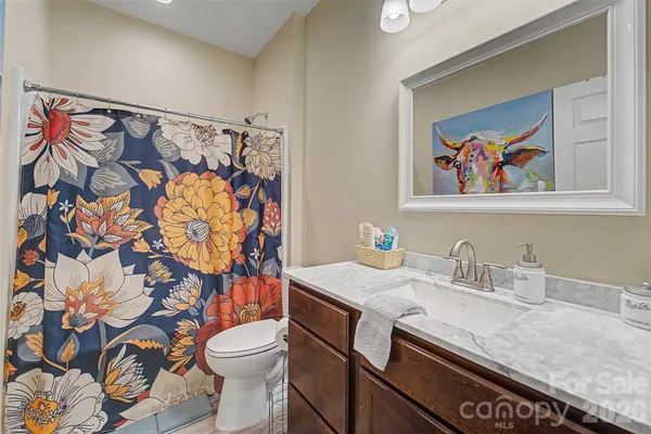 a bathroom with a granite countertop sink and a toilet