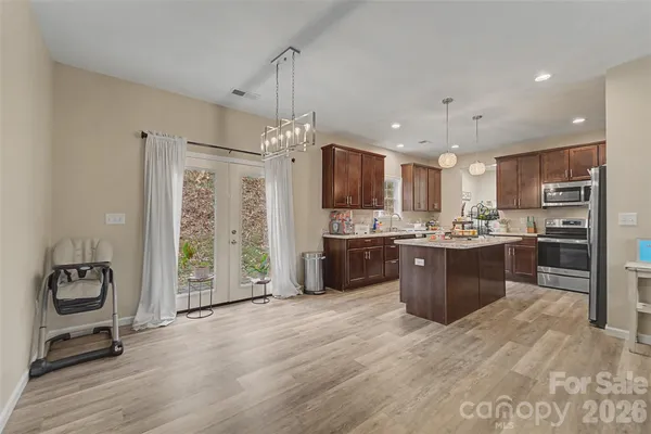 a kitchen with stainless steel appliances kitchen island granite countertop a refrigerator and a stove top oven