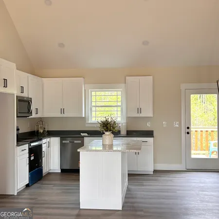 a kitchen with a sink cabinets and wooden floor