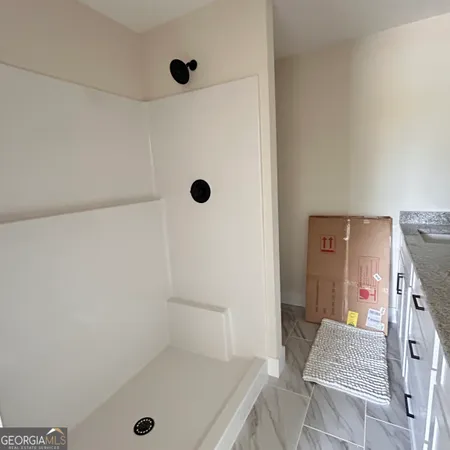 an empty room with a window and a fan
