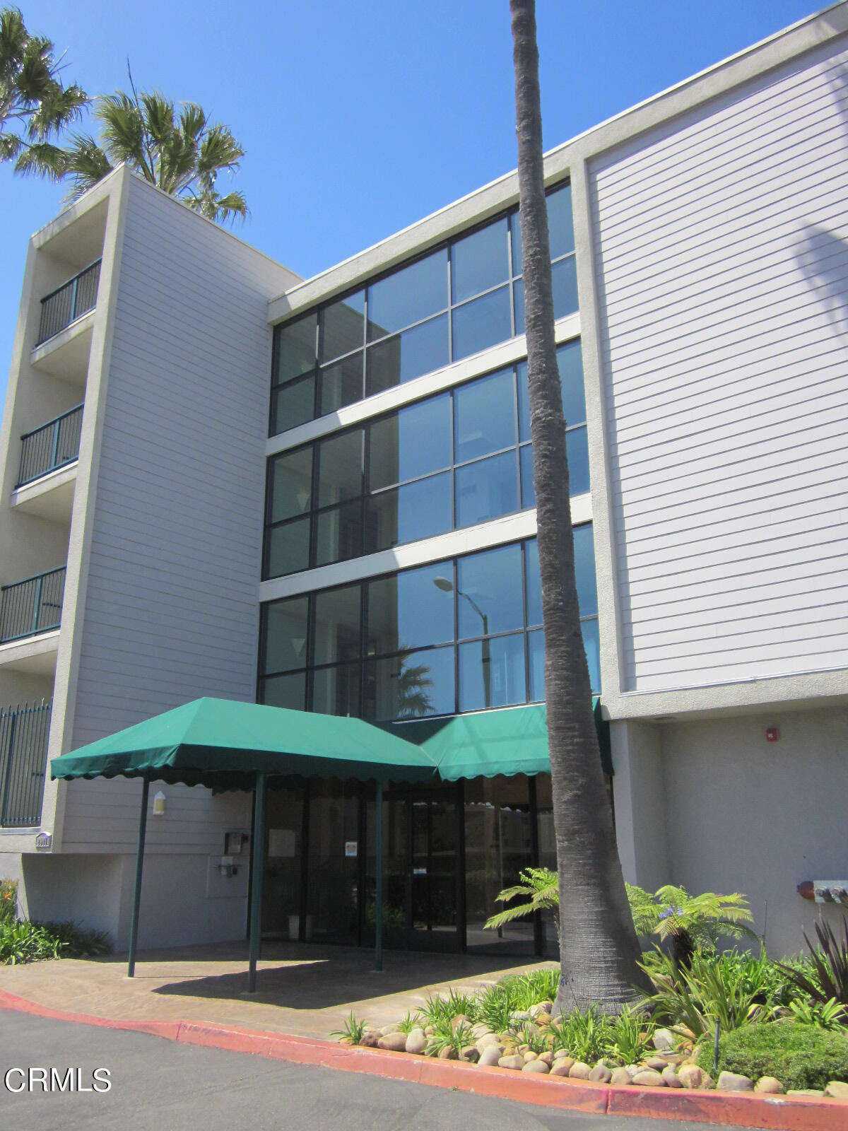 2901 Peninsula Road, Unit 242 Oxnard, CA 93035 - Photo 2 of 20 a front view of a house with a yard and garage