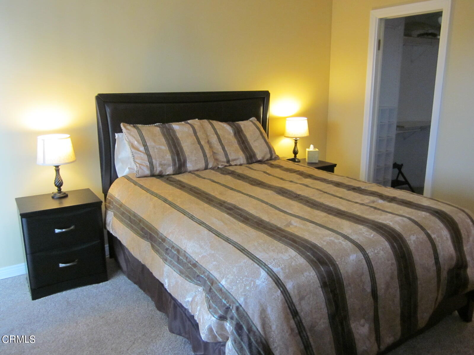 2901 Peninsula Road, Unit 242 Oxnard, CA 93035 - Photo 9 of 20 a bedroom with a bed and a lamp