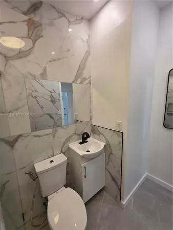 a bathroom with a sink a toilet and a mirror
