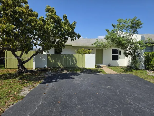 a view of a house with a tree and plants