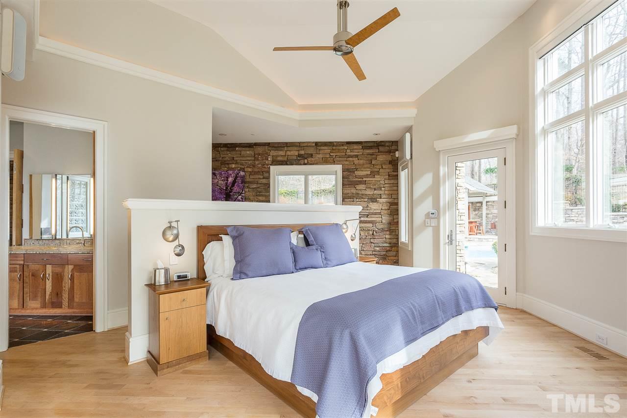 1117 Baslow Brook Court Raleigh, NC 27614 - Photo 17 of 30 a bedroom with a large bed and a chandelier