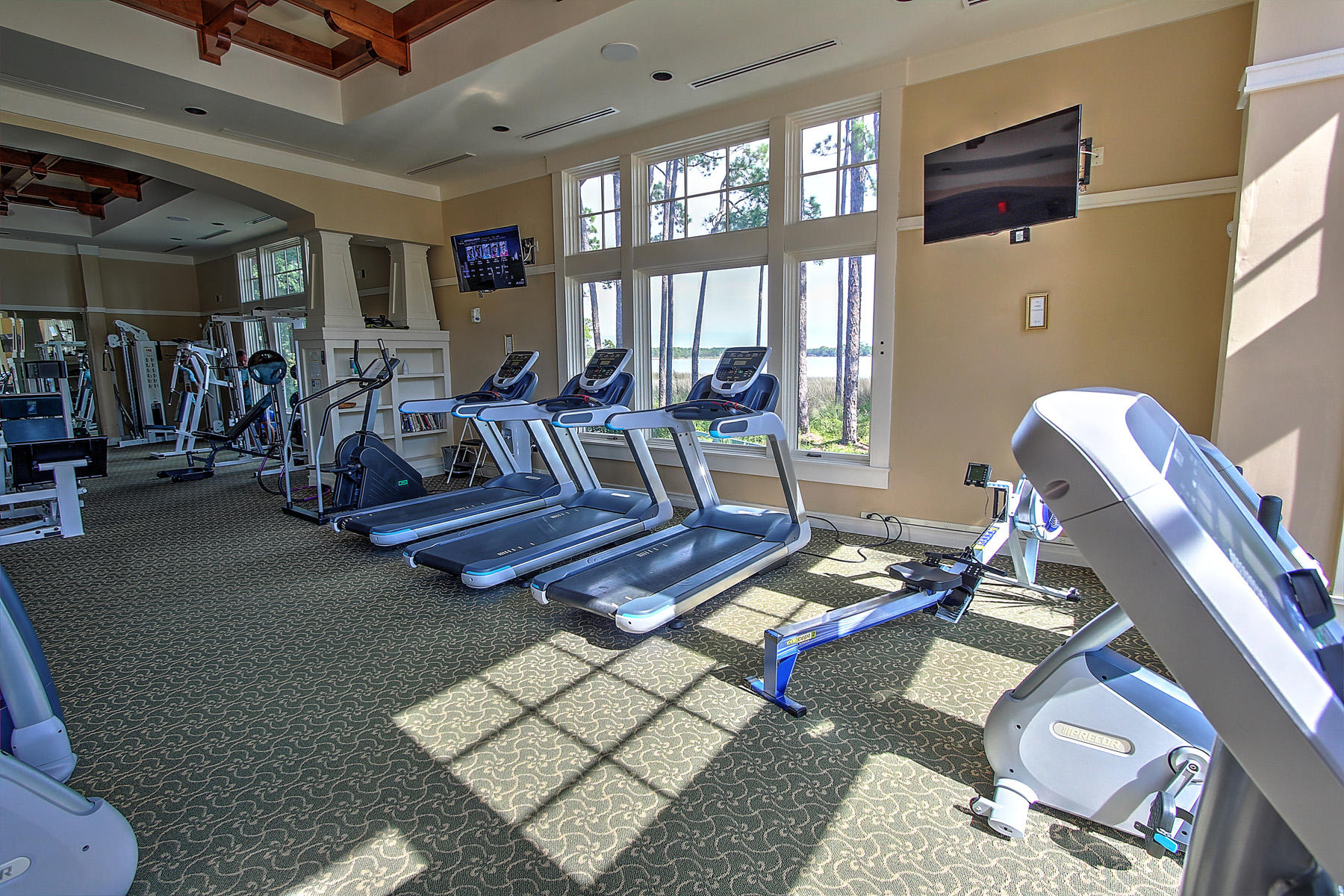 1101 Prospect Promenade, Unit 401 Panama City Beach, FL 32413 - Photo 27 of 35 a living room with lots of furniture and gym equipment
