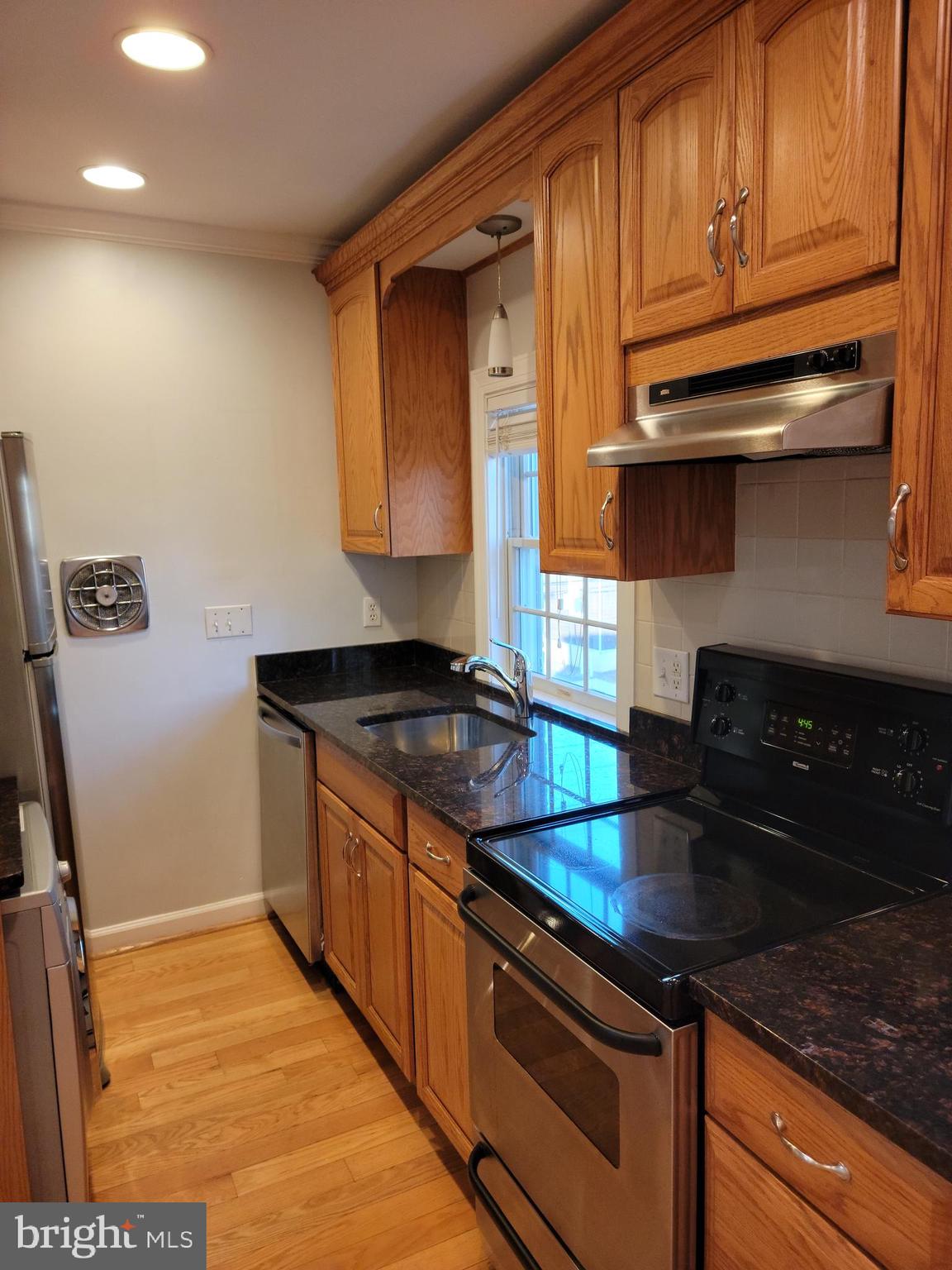133 North Payne Street, Unit 2 Alexandria, VA 22314 - Photo 8 of 16 a kitchen with granite countertop stainless steel appliances a stove a sink and a microwave
