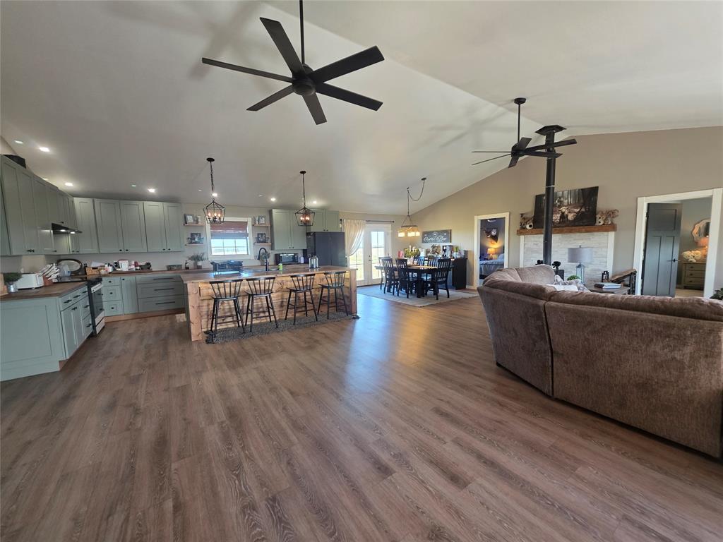 a living room with stainless steel appliances kitchen island granite countertop wooden floors and view living room