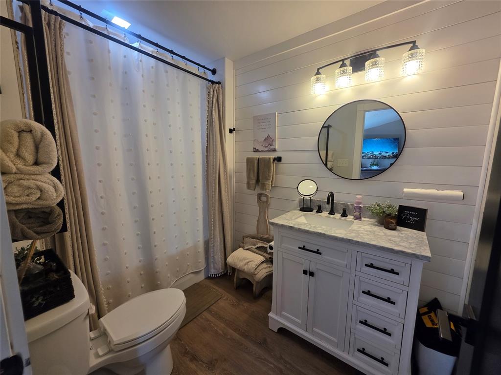 1225 R R G Loop Olney, TX 76374 - Photo 16 of 40 a bathroom with a granite countertop sink toilet a mirror and shower