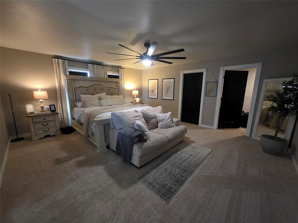 1225 R R G Loop Olney, TX 76374 - Photo 17 of 40 a spacious bedroom with a bed and a chandelier