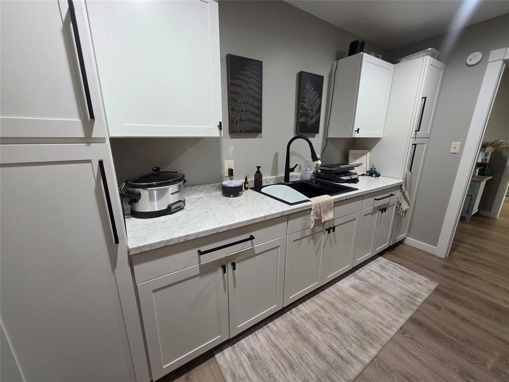 1225 R R G Loop Olney, TX 76374 - Photo 23 of 40 a kitchen with sink a microwave a stove and cabinets