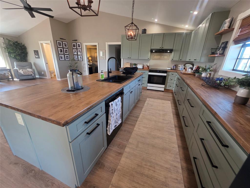 1225 R R G Loop Olney, TX 76374 - Photo 7 of 40 a large kitchen with kitchen island a large counter top a sink a stove and a center island
