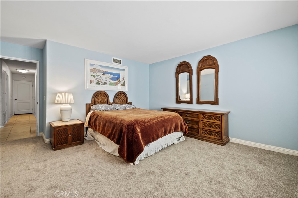 28784 Eagleton Street Agoura Hills, CA 91301 - Photo 30 of 48 a spacious bedroom with a bed and a painting on the wall