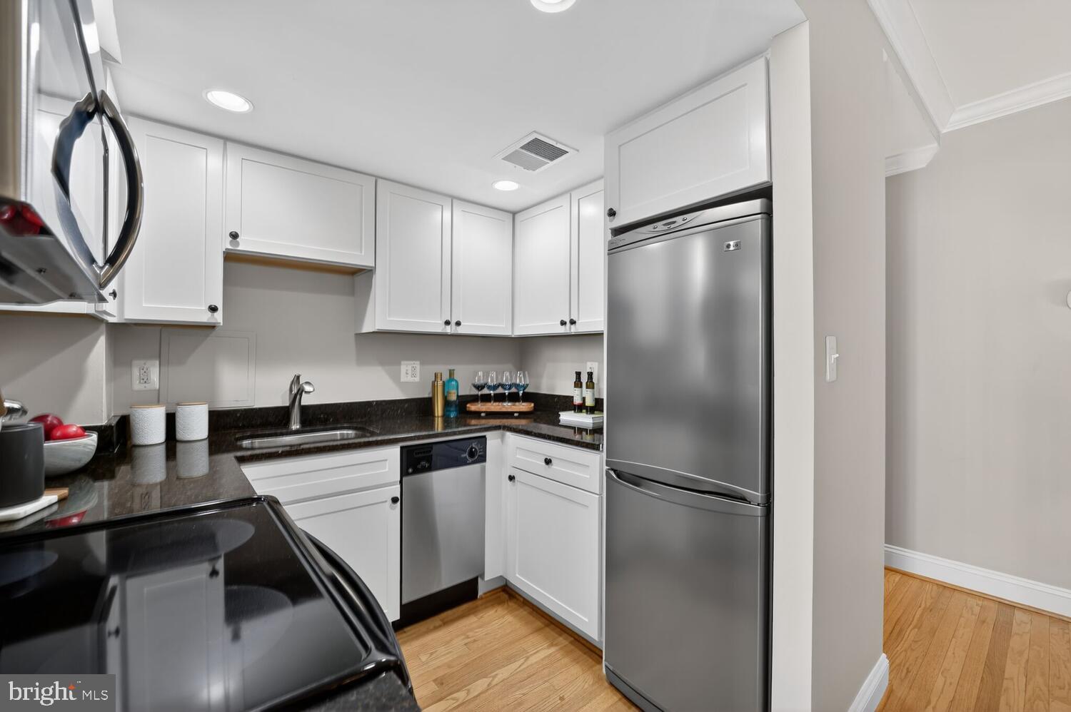 1701 16th Street Northwest, Unit 440 Washington, DC 20009 - Photo 12 of 31 a kitchen with stainless steel appliances granite countertop a refrigerator sink and cabinets