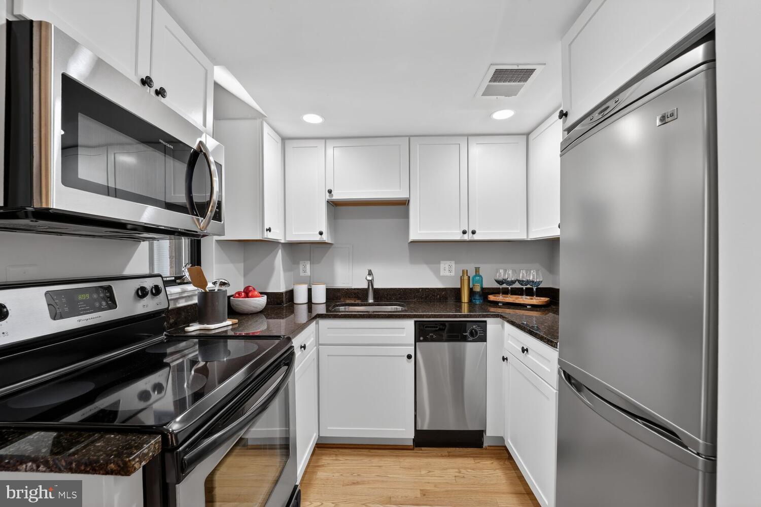 1701 16th Street Northwest, Unit 440 Washington, DC 20009 - Photo 10 of 31 a kitchen with stainless steel appliances a stove a sink and a microwave