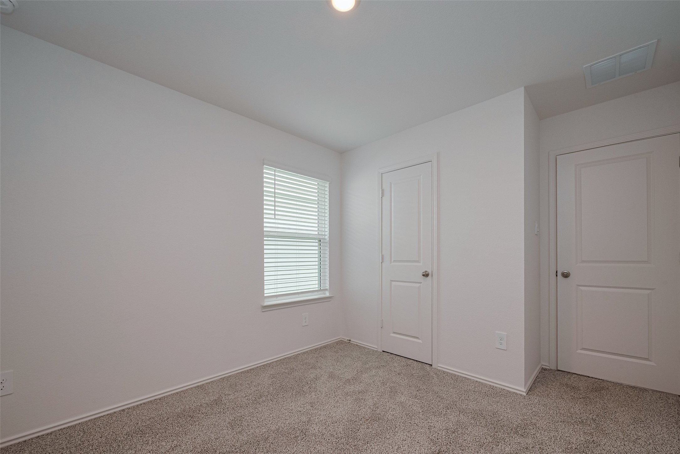 30842 Brightwell Bend Fulshear, TX 77441 - Photo 19 of 31 The third bedroom continues the cohesive design, offering a peaceful atmosphere with natural light, cozy carpeting, and ample space for personal style.