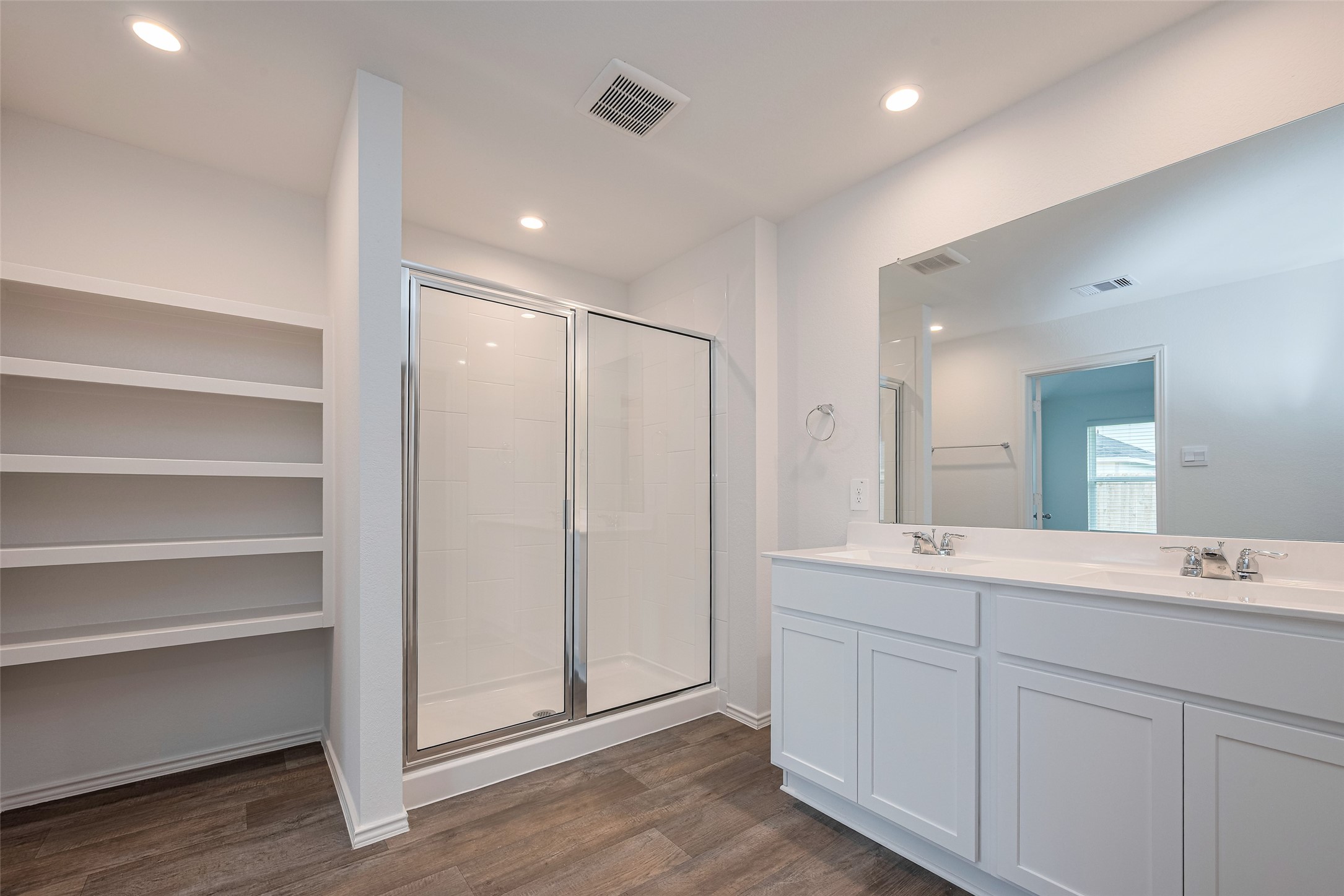 30842 Brightwell Bend Fulshear, TX 77441 - Photo 27 of 31 Spacious primary bath featuring a dual-sink vanity, oversized walk-in shower, and built-in shelving for added storage. Clean finishes and soft lighting create a spa-like feel