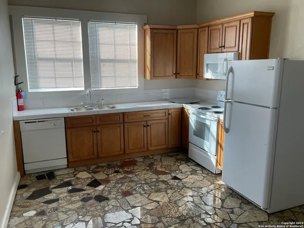 a kitchen with a refrigerator sink and cabinets
