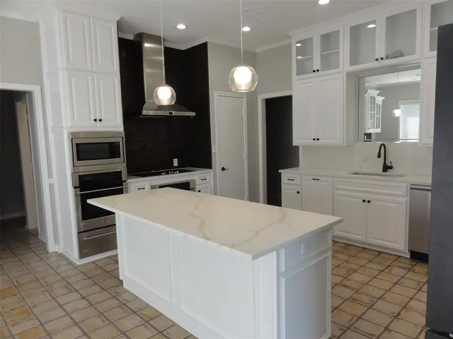 a kitchen with a sink appliances and cabinets