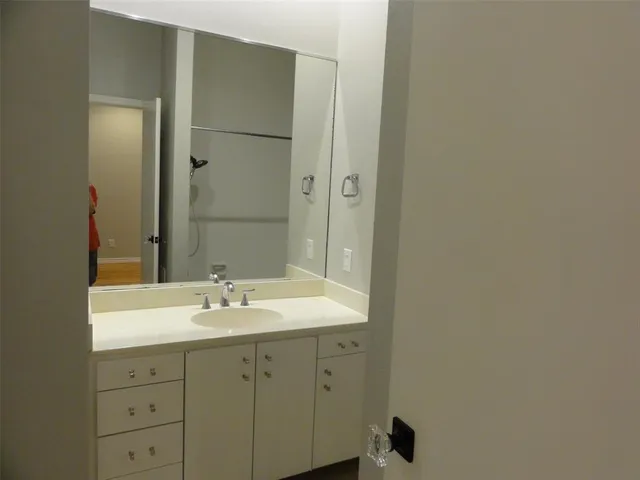 a bathroom with a granite countertop sink a toilet and shower