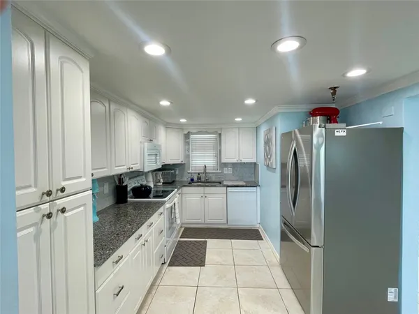 a kitchen with a refrigerator a sink and cabinets