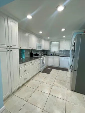 a kitchen with stainless steel appliances granite countertop a refrigerator and a sink