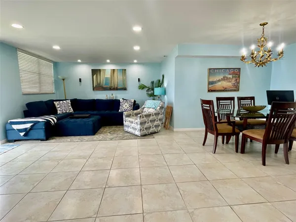 a living room with furniture a dining table and a chandelier