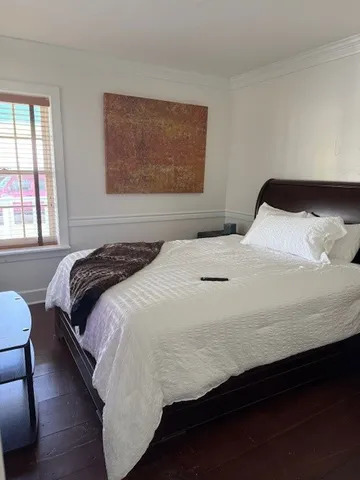 a bedroom with a bed and wooden floor