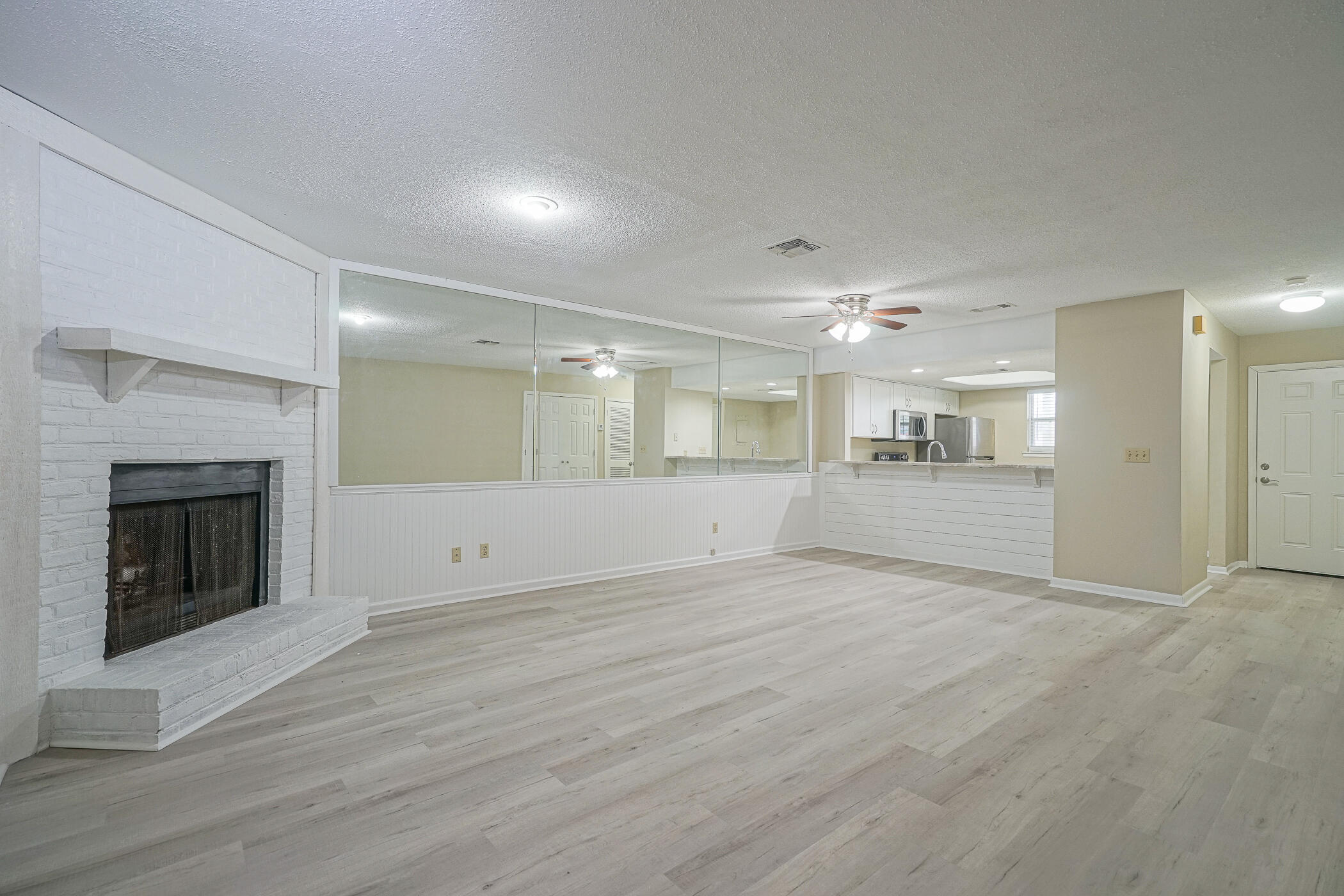 16 Court Drive Destin, FL 32541 - Photo 11 of 50 an empty room with wooden floor fireplace and windows
