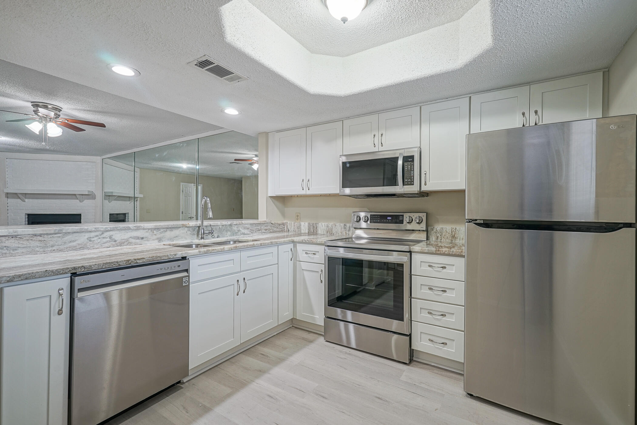 16 Court Drive Destin, FL 32541 - Photo 5 of 50 a kitchen with granite countertop a refrigerator stove and microwave