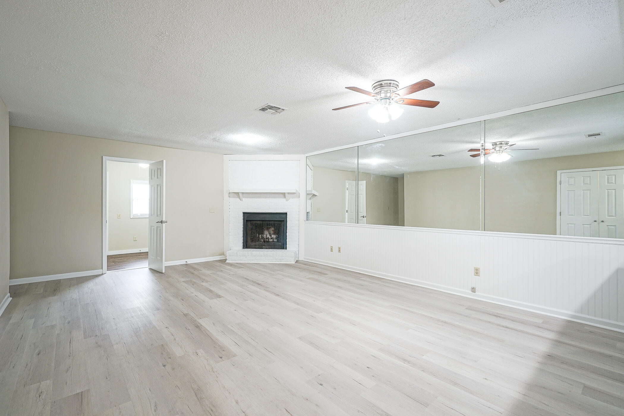 16 Court Drive Destin, FL 32541 - Photo 9 of 50 an empty room with wooden floor fan and windows