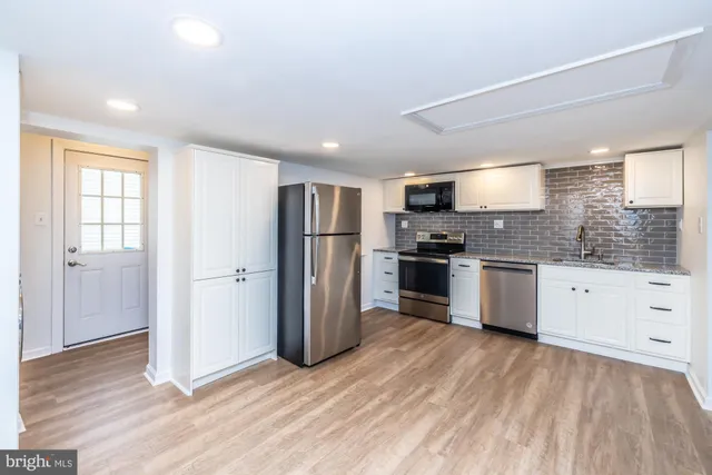 a kitchen with stainless steel appliances a refrigerator and wooden floor