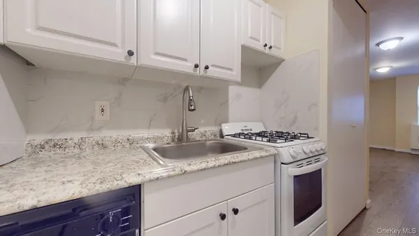 a kitchen with granite countertop a sink and a stove