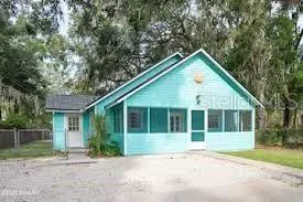 a view of front a house with a yard and potted plants