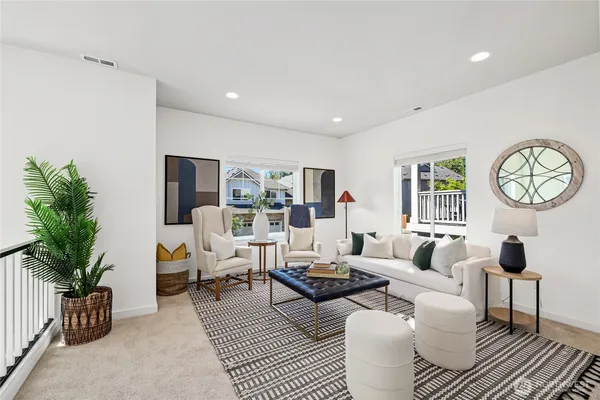 a living room with furniture a rug potted plant and a window
