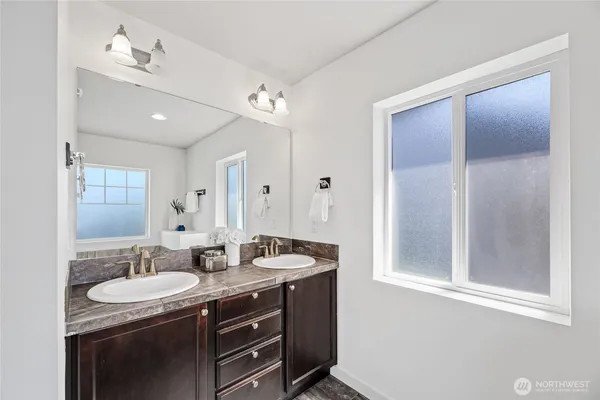 a bathroom with a granite countertop sink a mirror and a shower