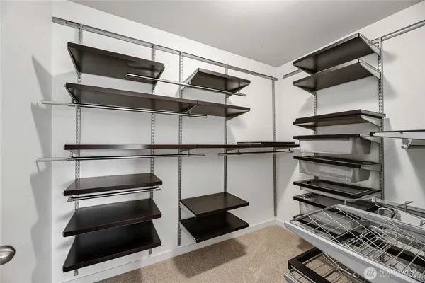 a view of walk in closet with clothes and shoes